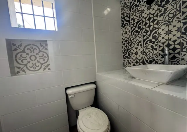 Salle de bain avec vasque à poser et mur en carreaux de ciment
